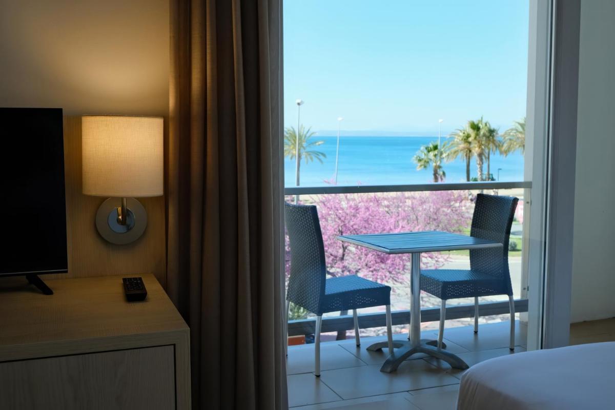Una habitación con balcón con mesa y sillas. en Hotel Marina, en Roses