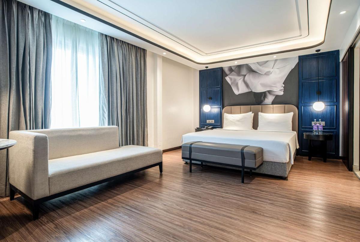 a bedroom with a bed and a couch and a chair at Radisson Blu Hotel Ahmedabad in Ahmedabad