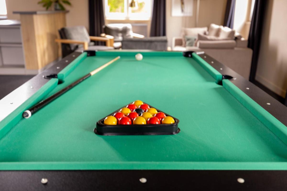une table de billard verte avec des ajustements dans l'établissement Logis Hôtel Restaurant & Spa La Rochette, à Labaroche