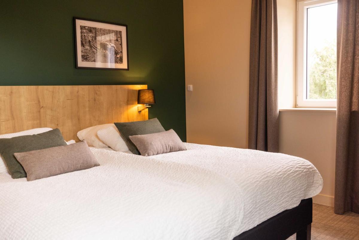 Un ou plusieurs lits dans un hébergement de l'établissement Logis Hôtel Restaurant & Spa La Rochette