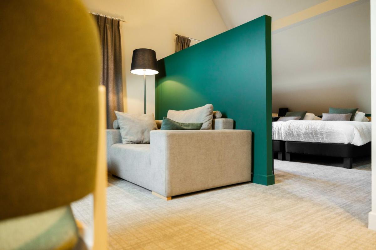 un salon avec un canapé et un lit dans l'établissement Logis Hôtel Restaurant & Spa La Rochette, à Labaroche