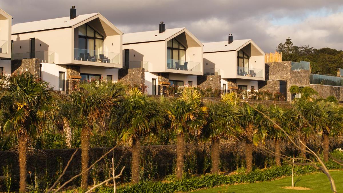 uma fila de casas numa colina com palmeiras em Azores Homes Resort & Spa em Ponta Delgada