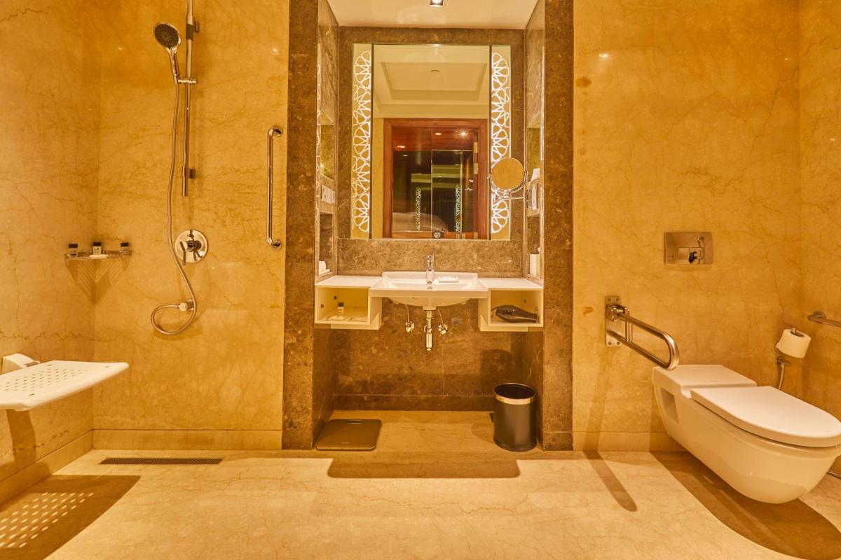 a bathroom with a toilet and a sink and a shower at Crowne Plaza New Delhi Rohini by IHG in New Delhi a bathroom with a toilet and a sink and a shower at Crowne Plaza New Delhi Rohini by IHG in New Delhi