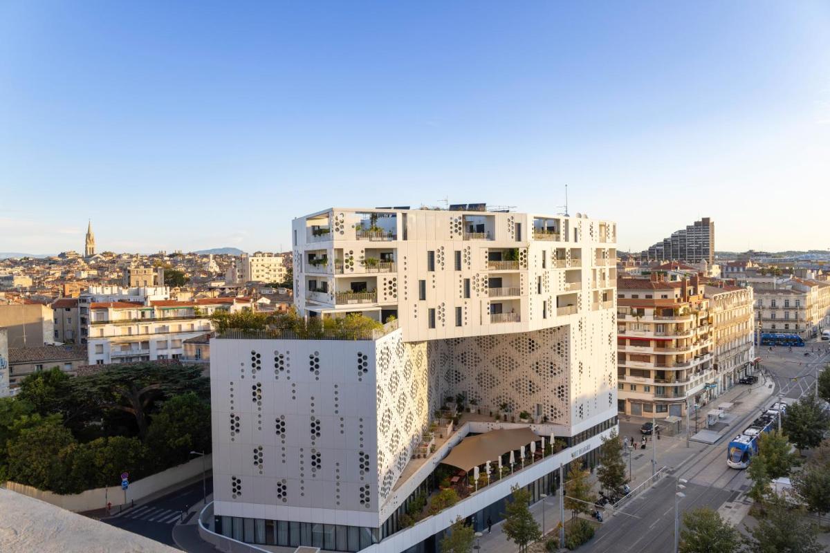 une image d'un bâtiment blanc dans une ville dans l'établissement Hotel Campanile Montpellier Centre St Roch, à Montpellier