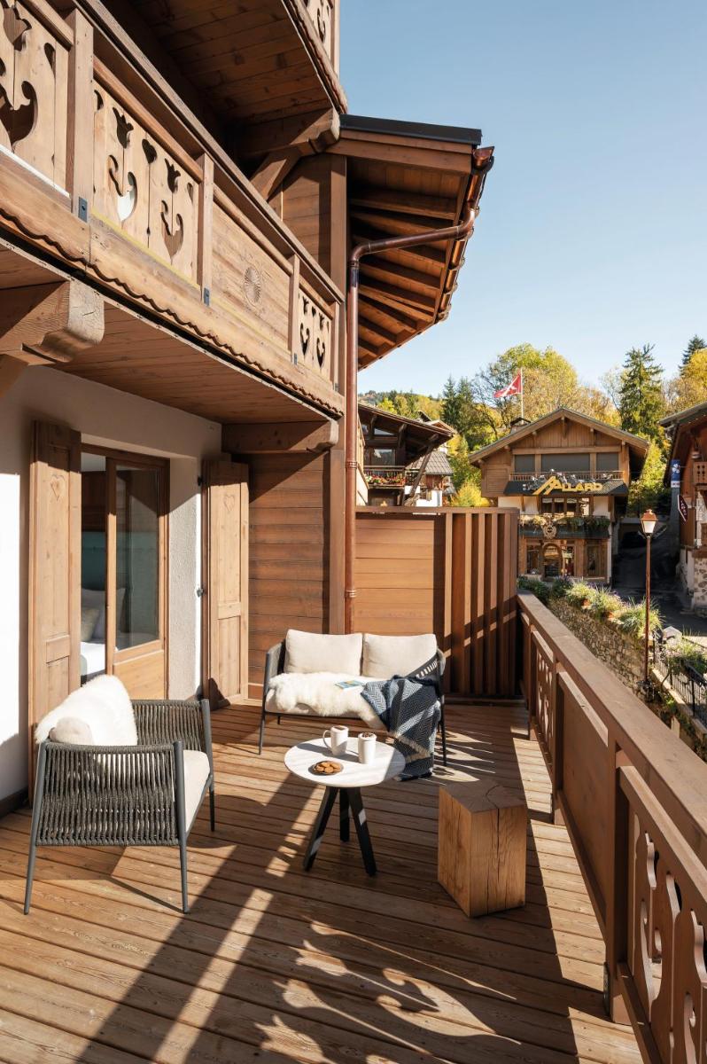 une terrasse avec deux chaises et une table sur un patio dans l'établissement Coeur de Megève, à Megève