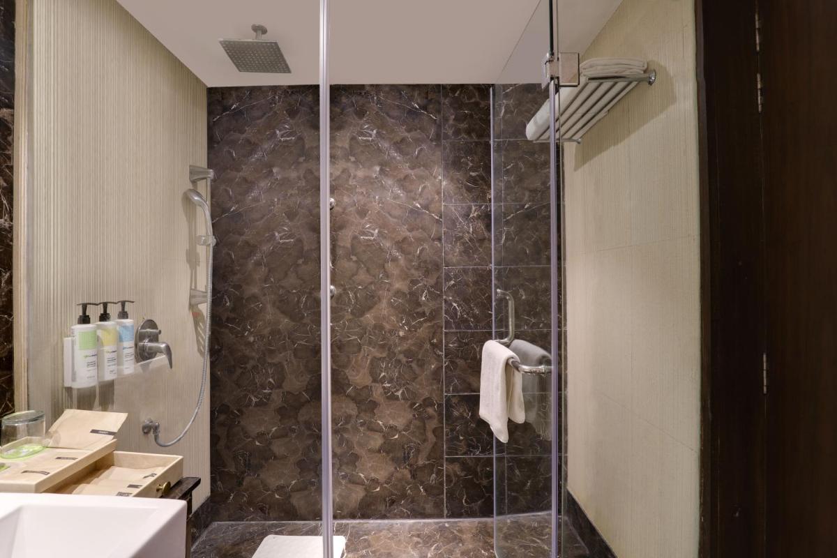 a bathroom with a shower with a glass door at Saura Hotel, Agra - A Club Mahindra Associate in Agra
