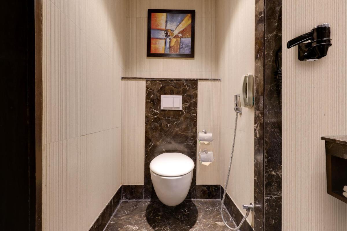 a bathroom with a white toilet and a shower at Saura Hotel, Agra - A Club Mahindra Associate in Agra