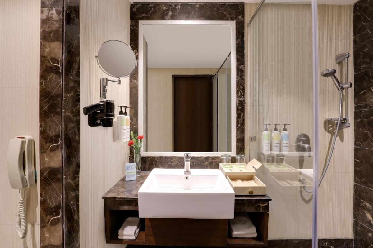 a bathroom with a sink and a mirror at Saura Hotel, Agra - A Club Mahindra Associate in Agra