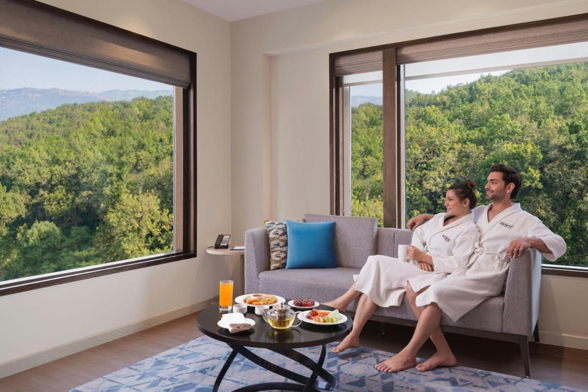 a man and woman sitting on a couch in front of a window at Fairfield by Marriott Dehradun in Dehradun