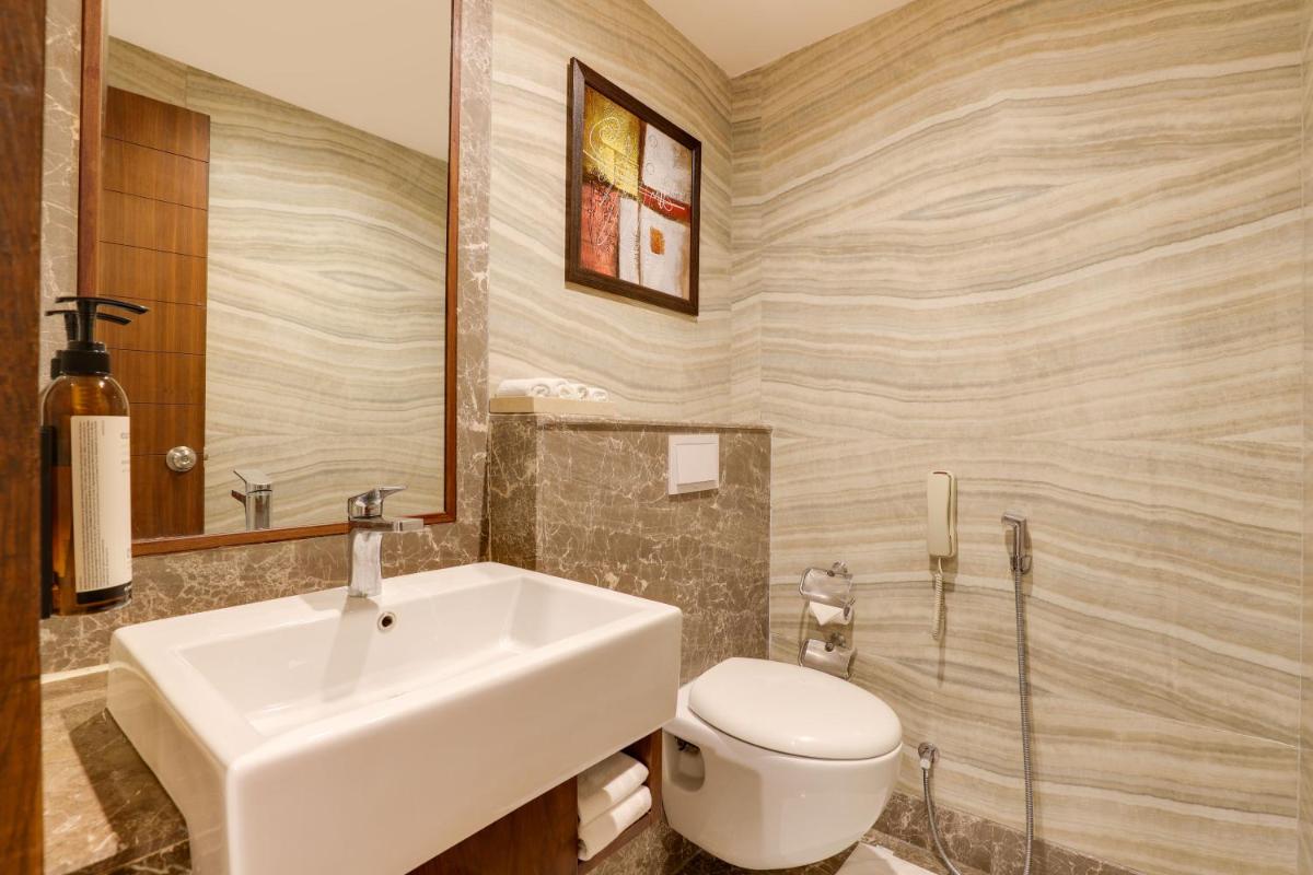 a bathroom with a sink and a toilet at Saura Hotel, Agra - A Club Mahindra Associate in Agra
