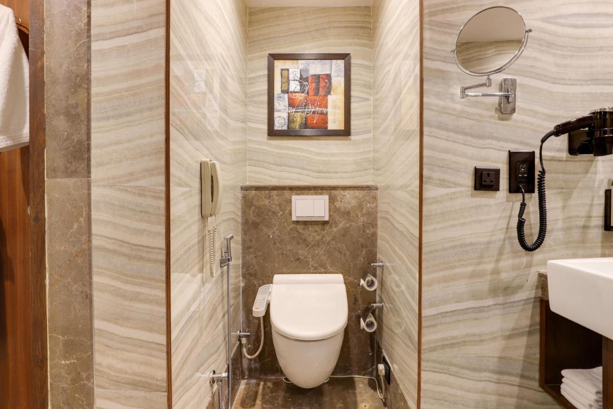 a bathroom with a toilet and a sink at Saura Hotel, Agra - A Club Mahindra Associate in Agra