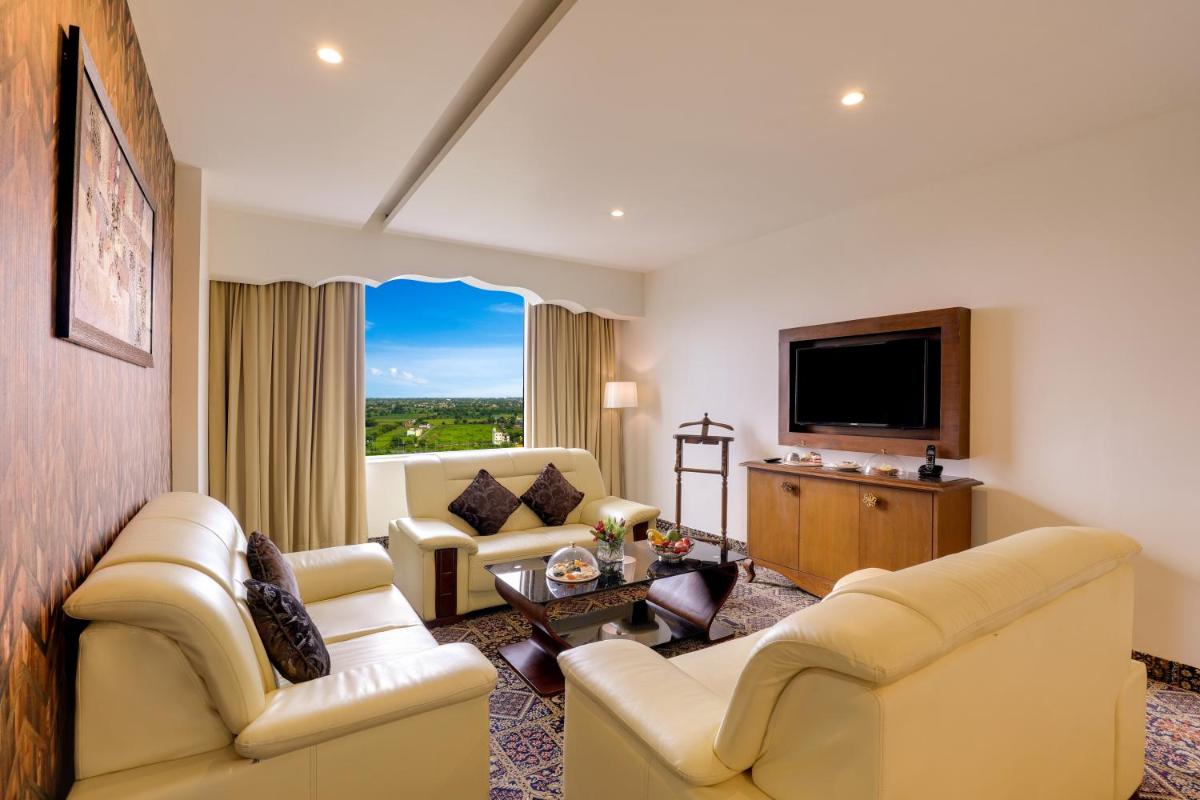 a living room with couches and a flat screen tv at Saura Hotel, Agra - A Club Mahindra Associate in Agra