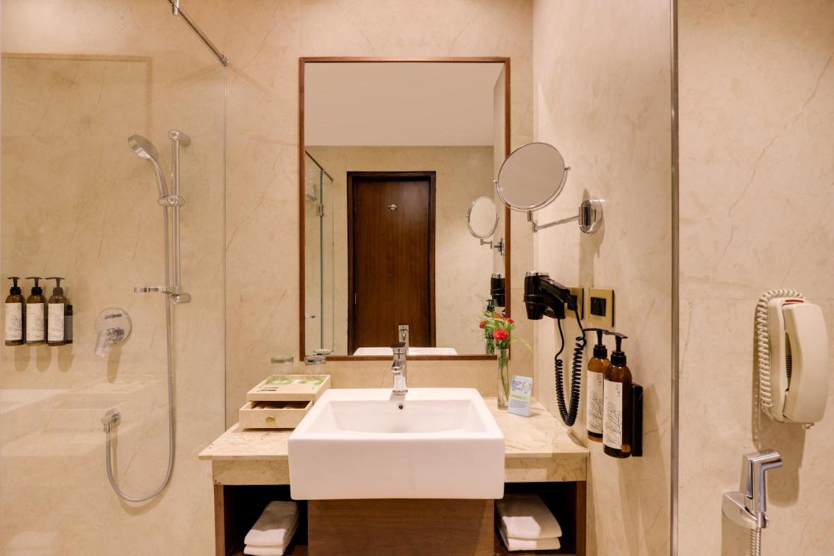 a bathroom with a sink and a shower at Saura Hotel, Agra - A Club Mahindra Associate in Agra