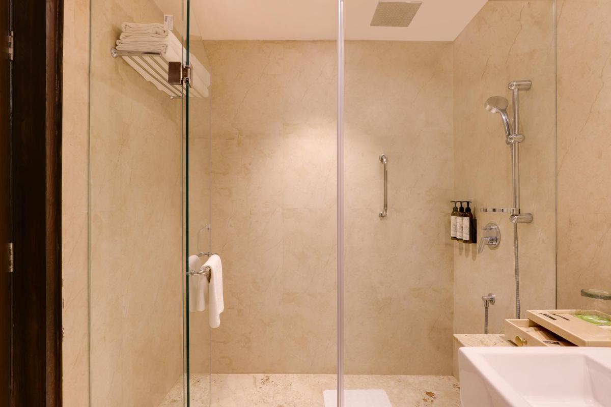 a shower with a glass door in a bathroom at Saura Hotel, Agra - A Club Mahindra Associate in Agra