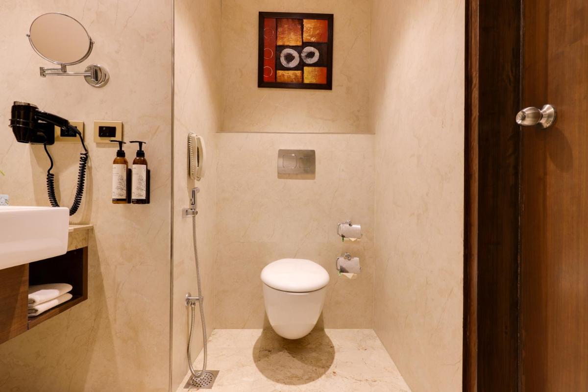 a bathroom with a toilet and a shower at Saura Hotel, Agra - A Club Mahindra Associate in Agra