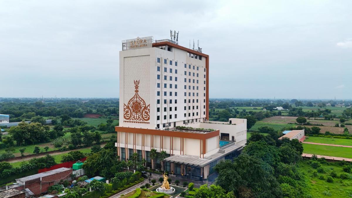 a tall white building with a clock on it at Saura Hotel, Agra - A Club Mahindra Associate in Agra