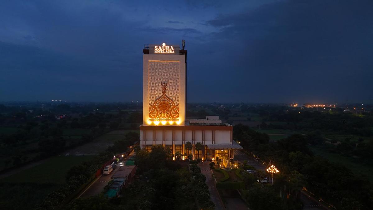 a building with a lit up tower at night at Saura Hotel, Agra - A Club Mahindra Associate in Agra