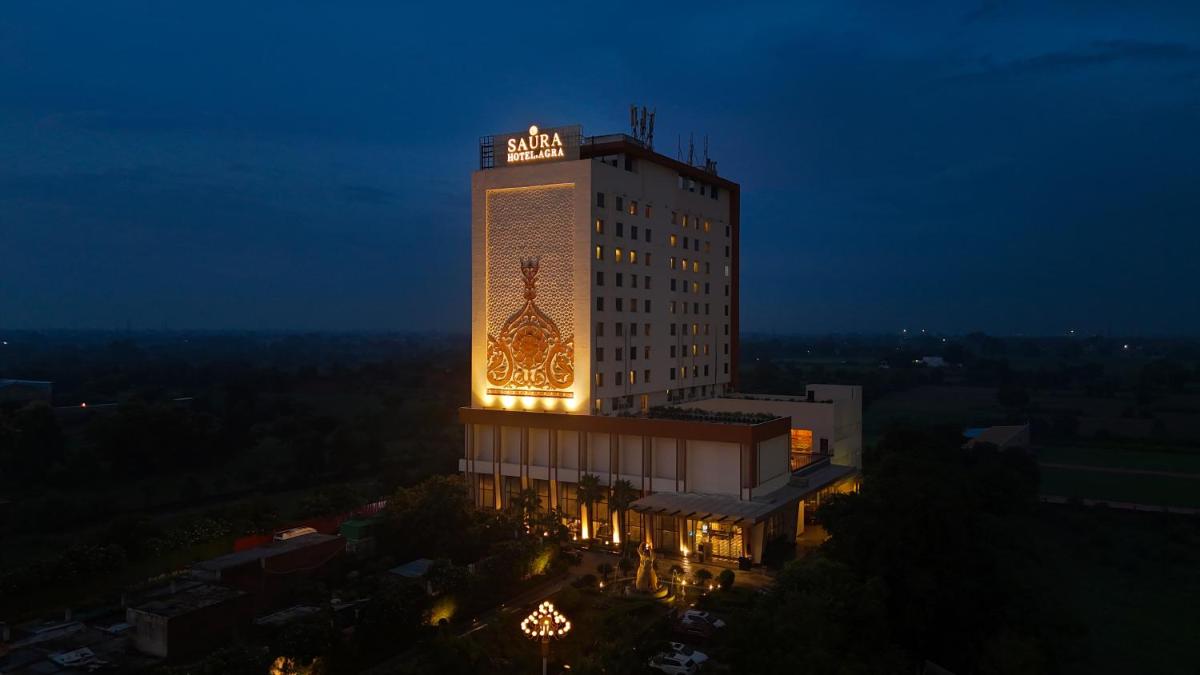 a building with a lit up sign on it at night at Saura Hotel, Agra - A Club Mahindra Associate in Agra