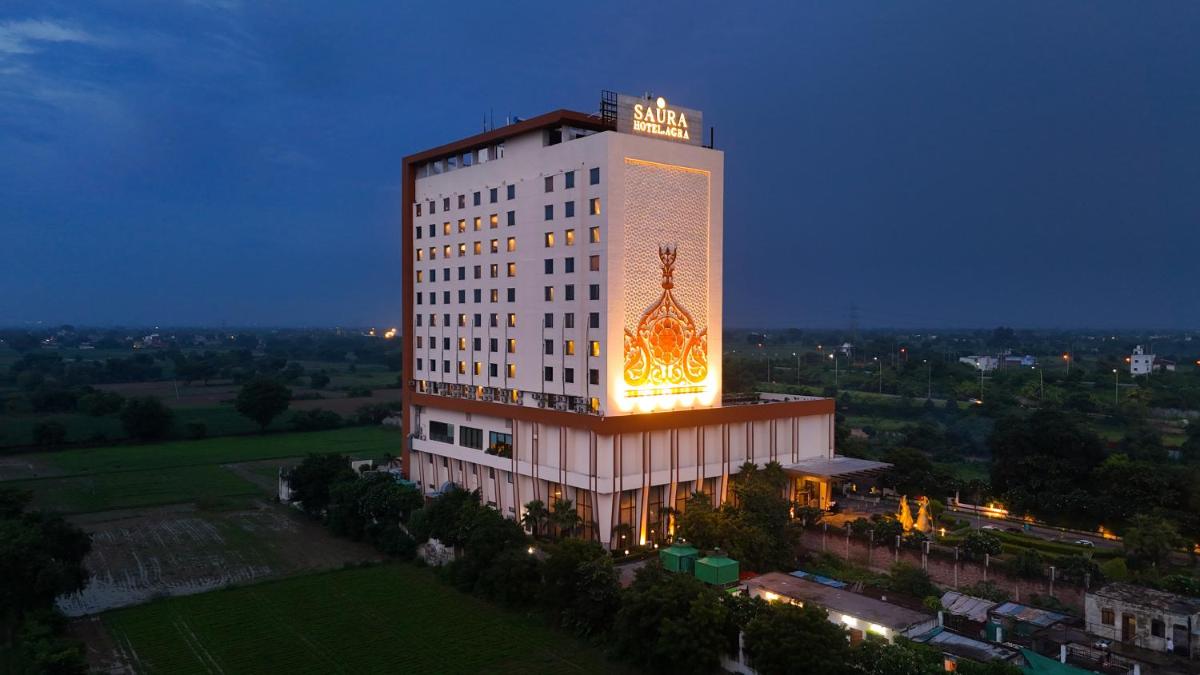 a tall building with a lit up sign on it at Saura Hotel, Agra - A Club Mahindra Associate in Agra