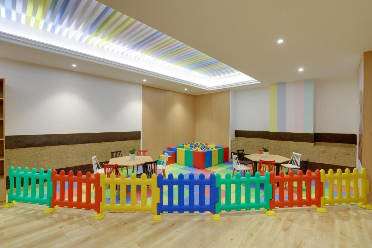 a room with tables and chairs and a wooden fence at Saura Hotel, Agra - A Club Mahindra Associate in Agra
