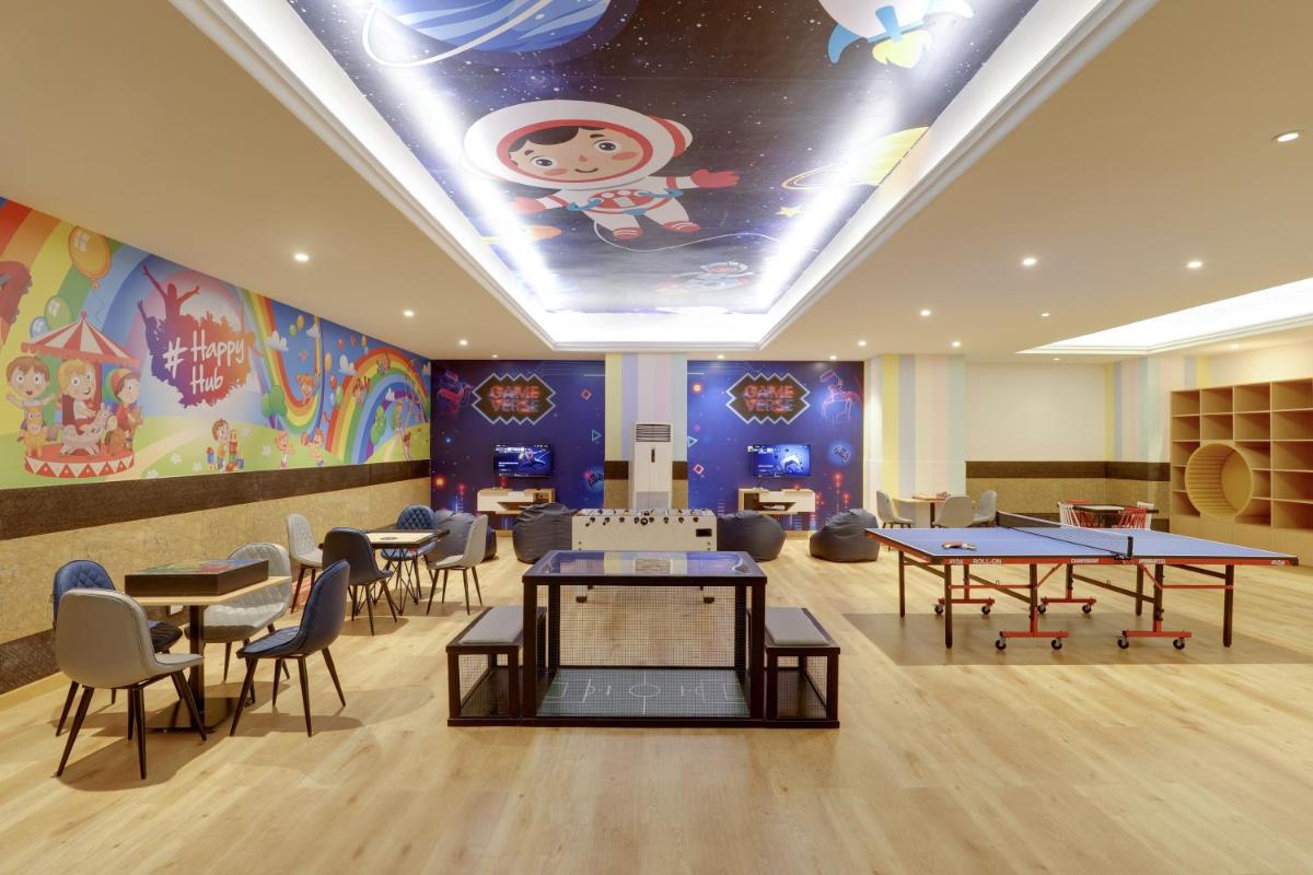 a restaurant with tables and chairs and a ceiling with a mural at Saura Hotel, Agra - A Club Mahindra Associate in Agra +83 photos