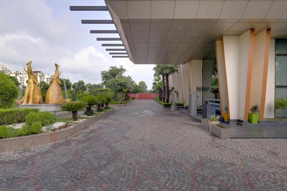 a walkway in front of a building with sculptures at Saura Hotel, Agra - A Club Mahindra Associate in Agra