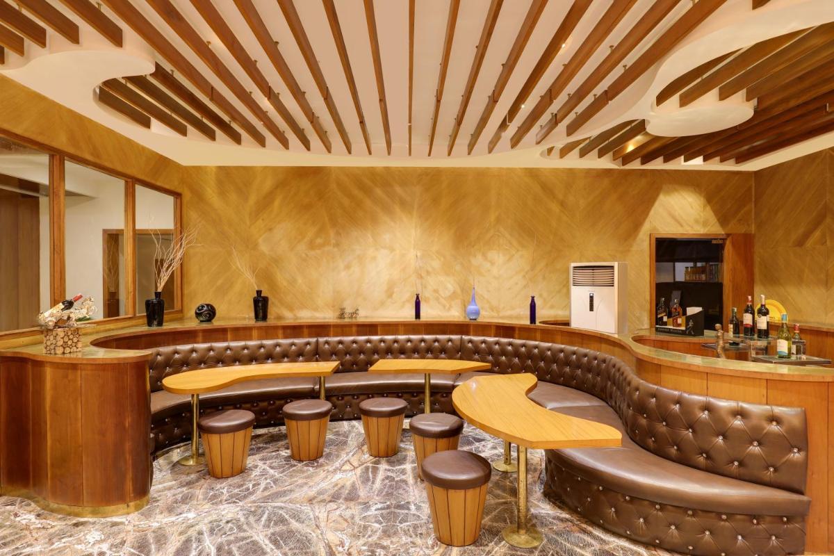 a restaurant with a leather couch and a bar at Saura Hotel, Agra - A Club Mahindra Associate in Agra