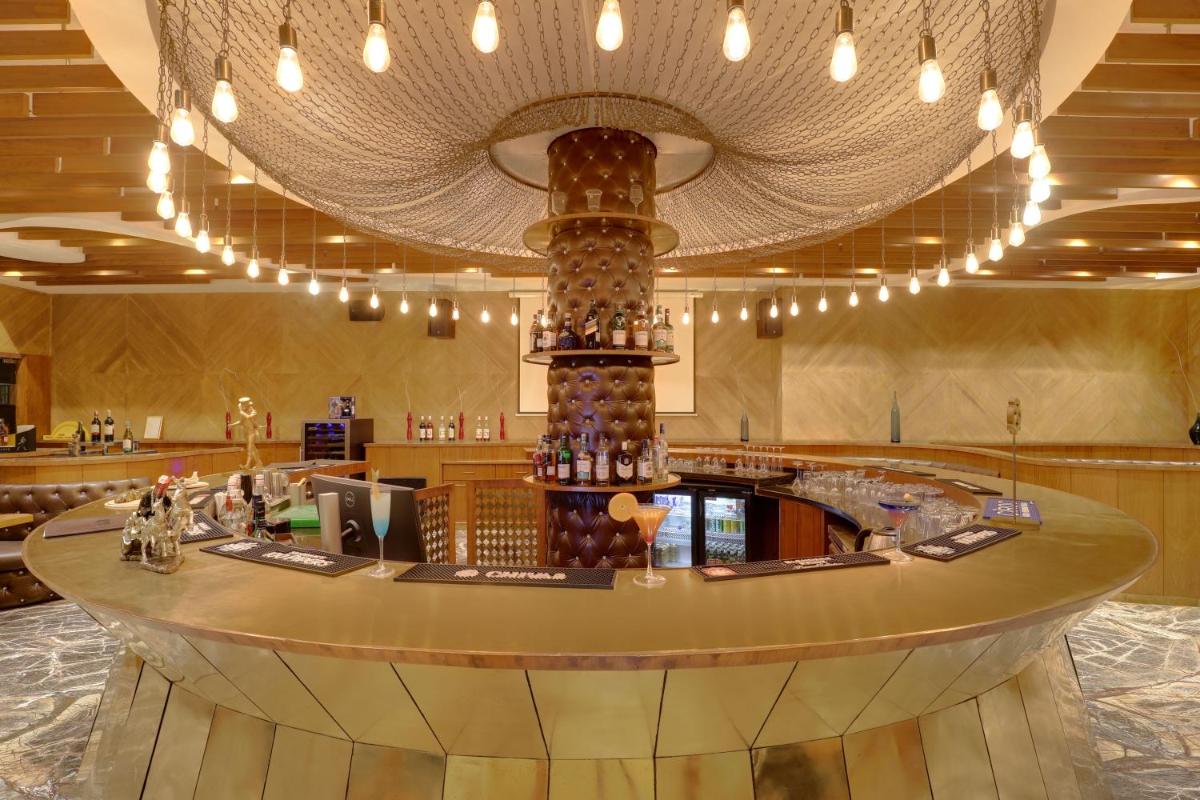 a lobby with a large chandelier above a bar at Saura Hotel, Agra - A Club Mahindra Associate in Agra