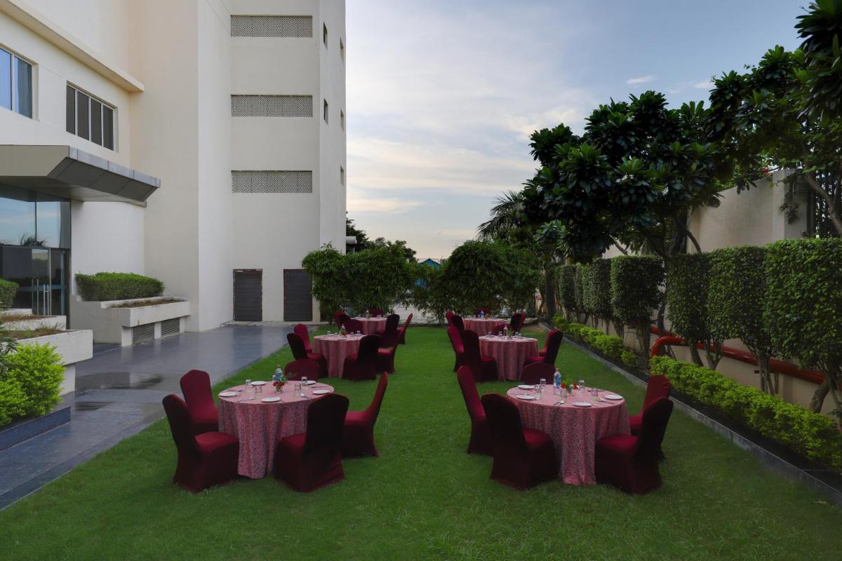 a restaurant with tables and chairs on the grass at Saura Hotel, Agra - A Club Mahindra Associate in Agra