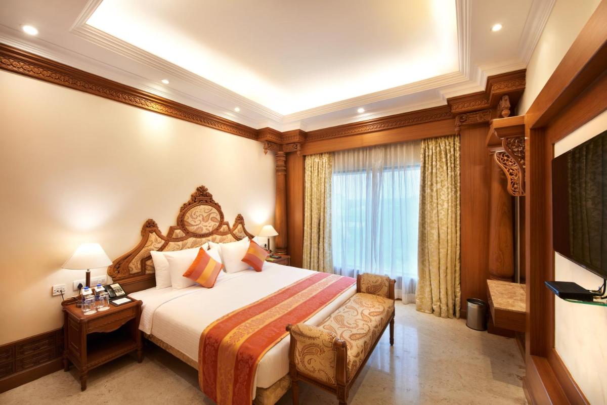 a hotel room with a bed and a window at Accord Puducherry in Puducherry
