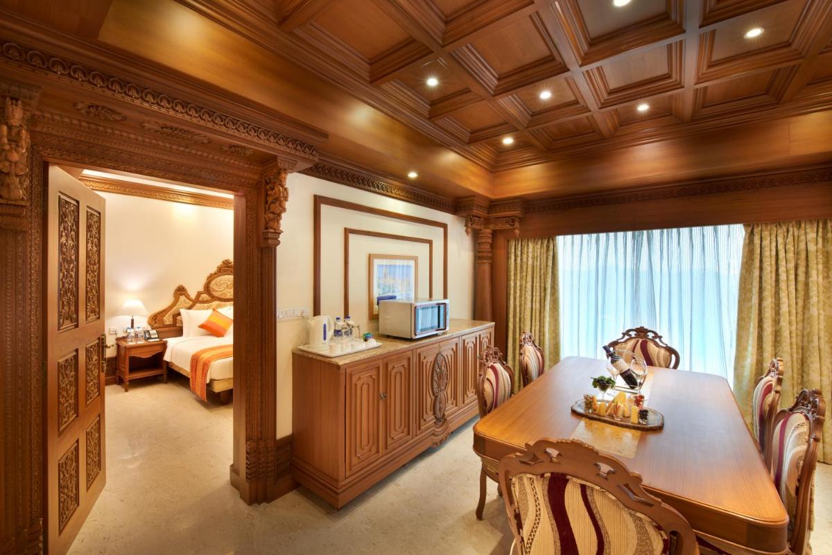 a room with a desk and a bedroom with a bed at Accord Puducherry in Puducherry