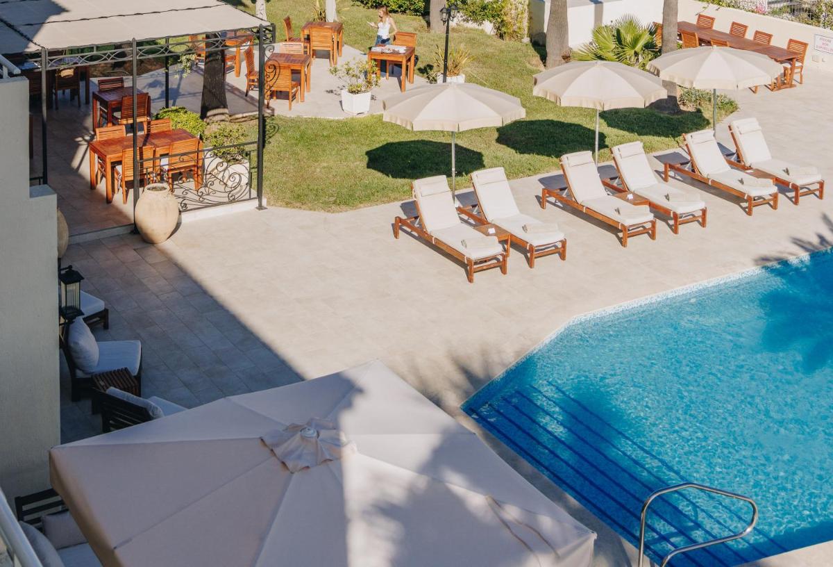 une vue aérienne d'une piscine avec des chaises et des parasols dans l'établissement Hotel Corsica & Spa Serena, à Calvi