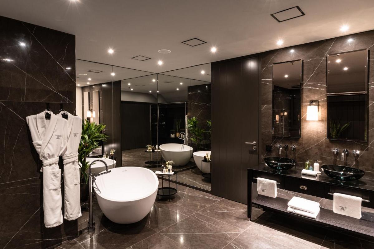 ein Badezimmer mit 2 Waschbecken und 2 Badewannen in der Unterkunft DO & CO Hotel München in München ein Badezimmer mit 2 Waschbecken und 2 Badewannen in der Unterkunft DO & CO Hotel München in München