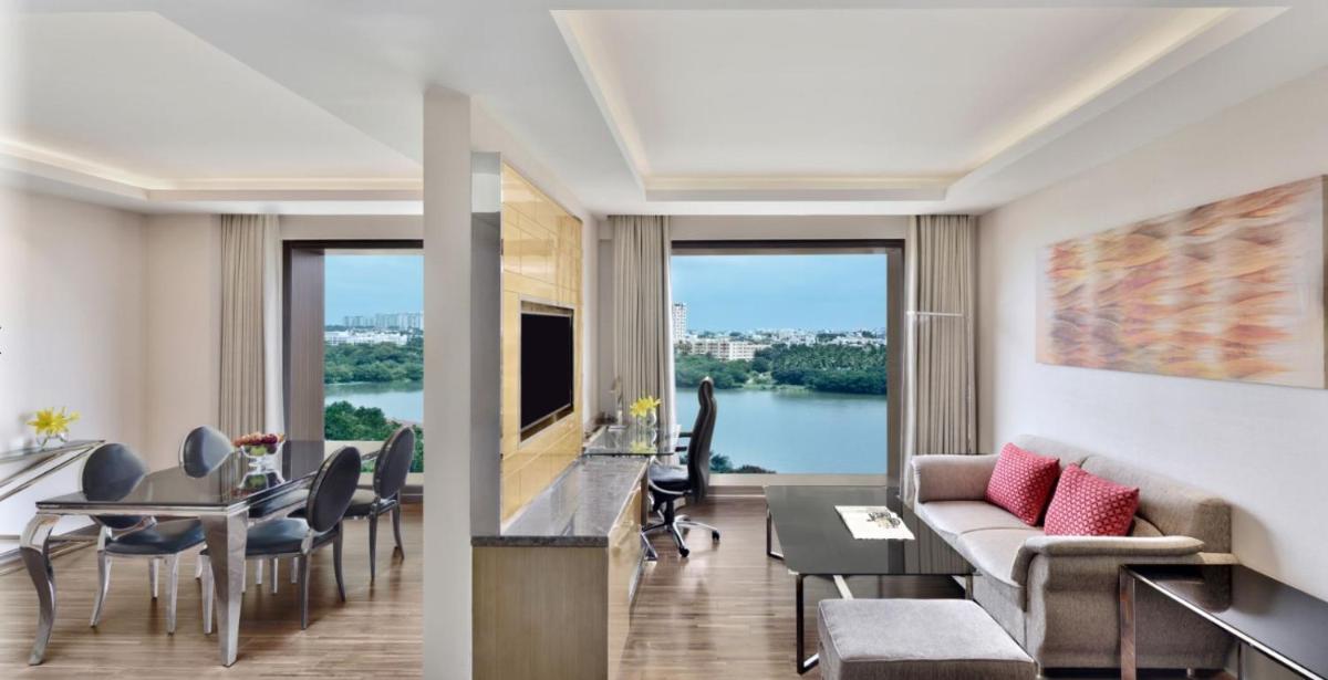 a living room with a couch and a table with chairs at Courtyard by Marriott Bengaluru Hebbal in Bengaluru