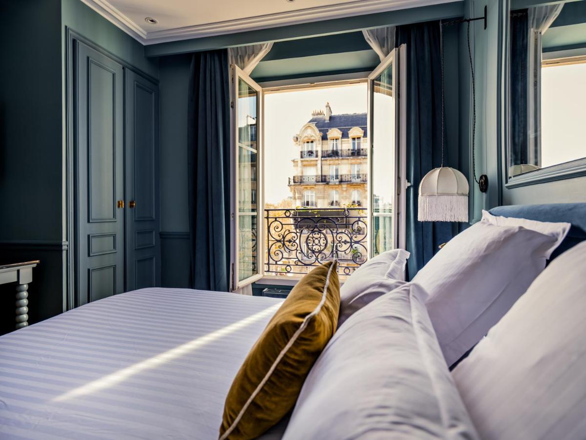 - une chambre avec un lit et une vue sur un bâtiment dans l'établissement Hotel Duquesne Eiffel, à Paris