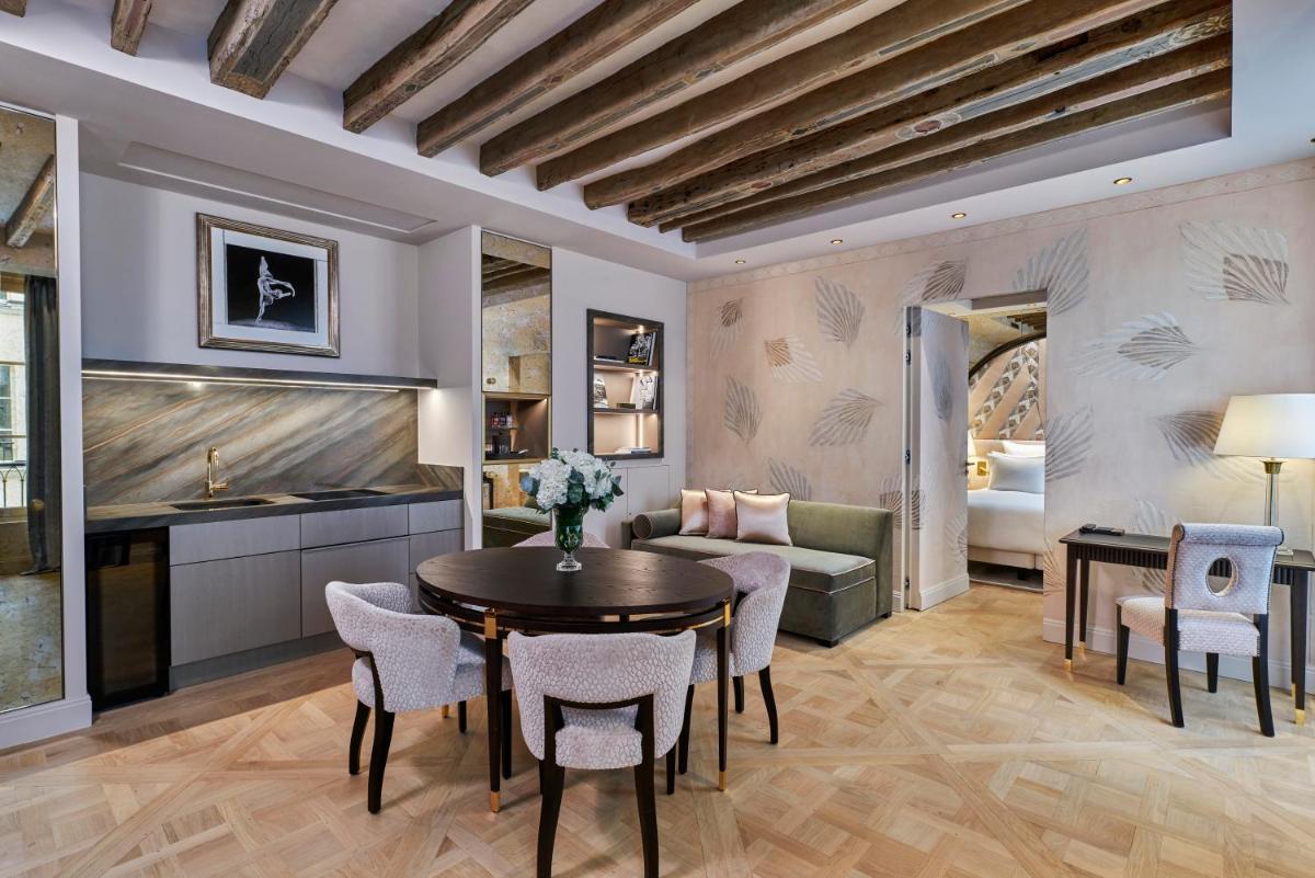 un salon avec une table, des chaises et un canapé dans l'établissement Maison Barrière Vendôme, à Paris