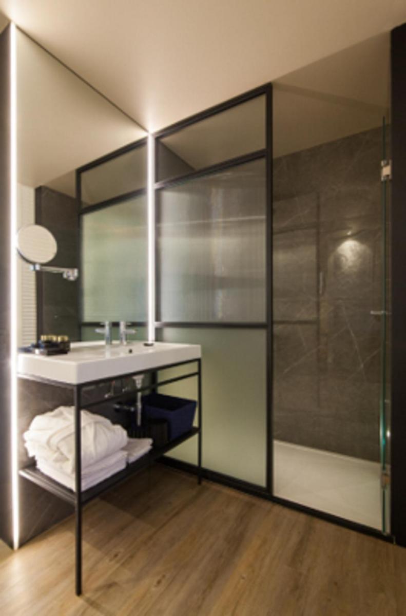 un baño con lavabo y ducha en Pestana Collection Plaza Mayor, en Madrid
