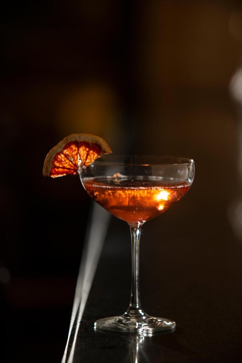 ein Getränk in einem Martiniglas mit orangefarbenem Touch in der Unterkunft Althoff Seehotel Überfahrt in Rottach-Egern + 37 Fotos