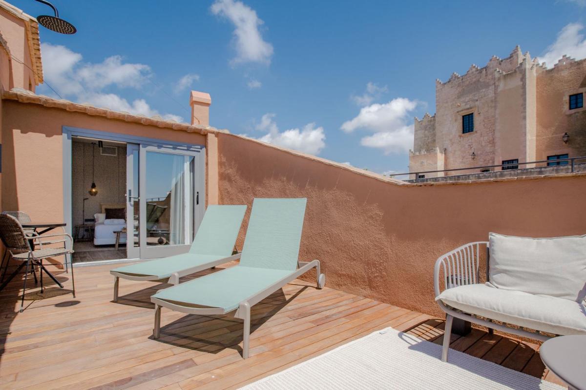 un patio con 2 sillas y una terraza de madera en Gran Claustre Boutique Hotel, en Altafulla