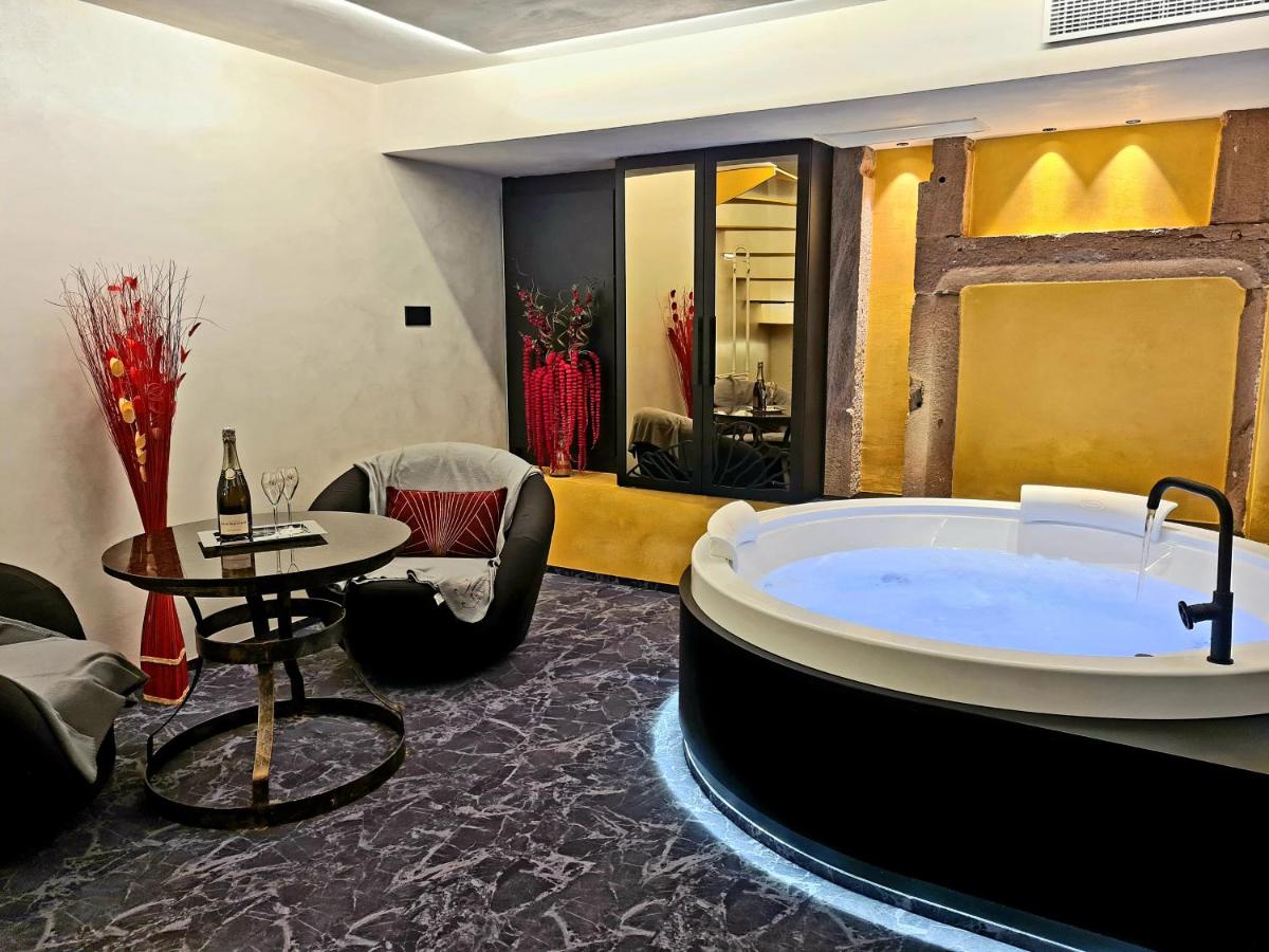 Cette chambre dispose d'une baignoire et d'une table. dans l'établissement Domaine du Haut Jardin Hôtel & Chalets Spa Privé, à Rehaupal