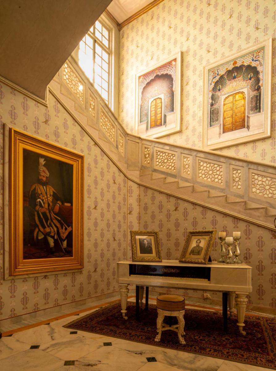 a room with a piano and a painting on the wall at Rajmahal Palace RAAS in Jaipur