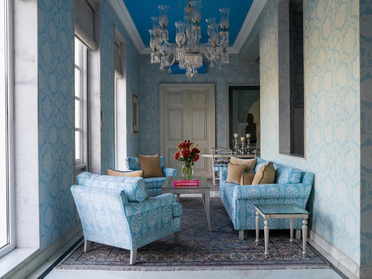 a living room with blue furniture and a chandelier at Rajmahal Palace RAAS in Jaipur