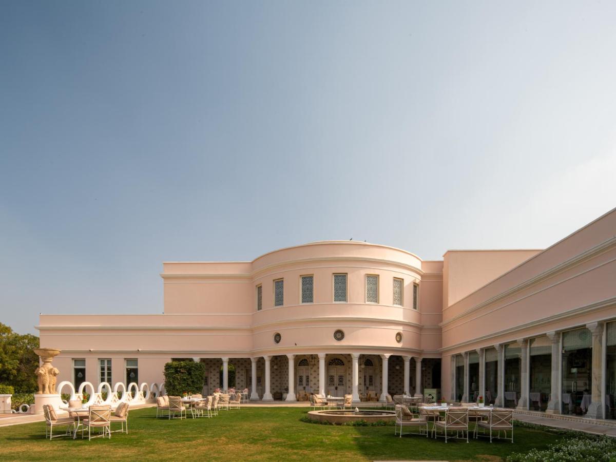 a large building with tables and chairs on the lawn at Rajmahal Palace RAAS in Jaipur