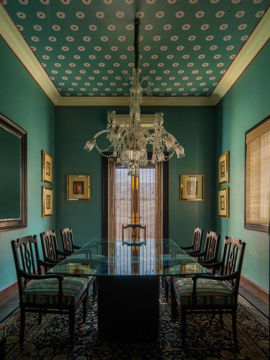 a dining room with a glass table and a chandelier at Rajmahal Palace RAAS in Jaipur