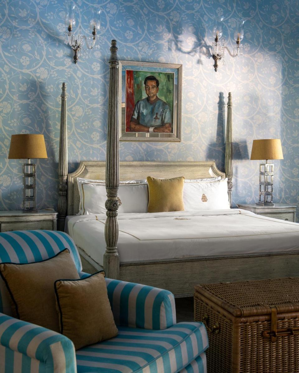 a bedroom with a king sized bed with blue wallpaper at Rajmahal Palace RAAS in Jaipur