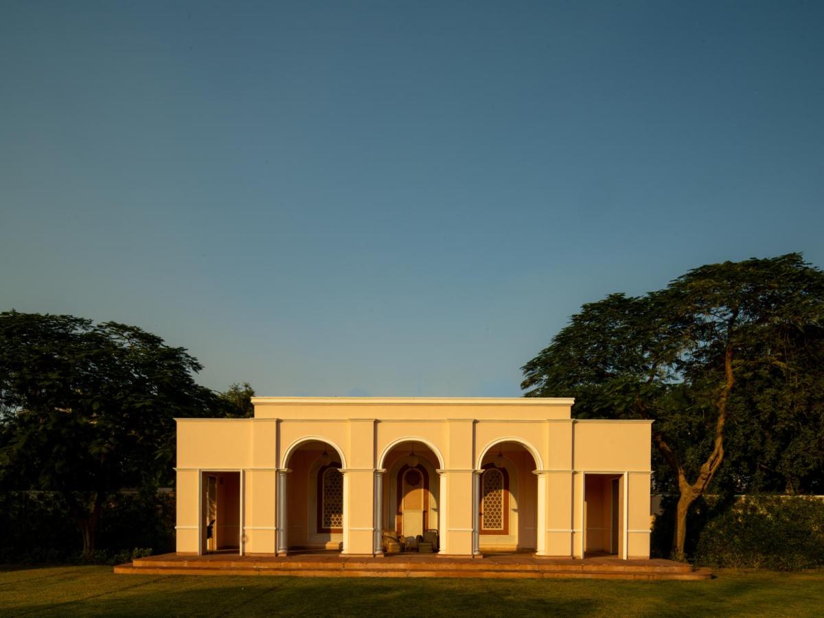 a white building with trees in the background at Rajmahal Palace RAAS in Jaipur