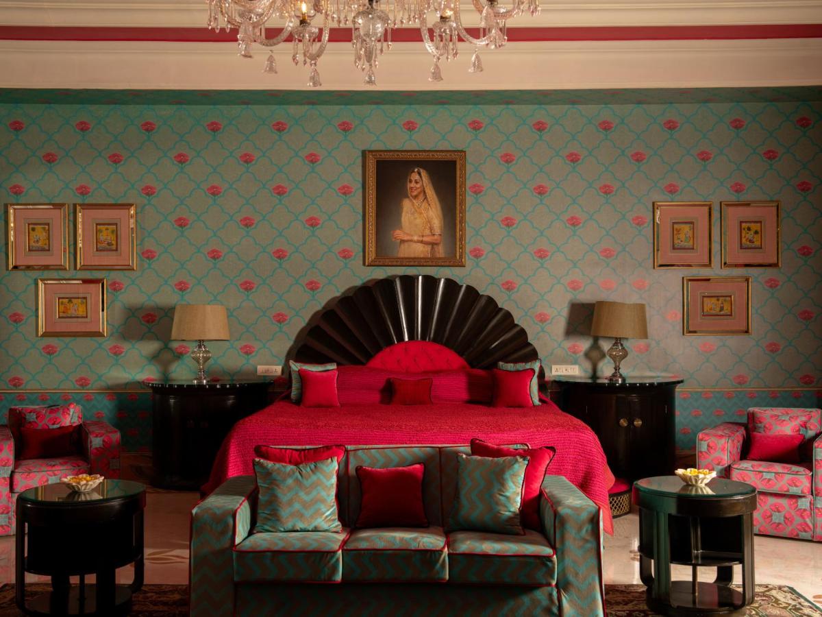 a bedroom with a red bed and a couch at Rajmahal Palace RAAS in Jaipur