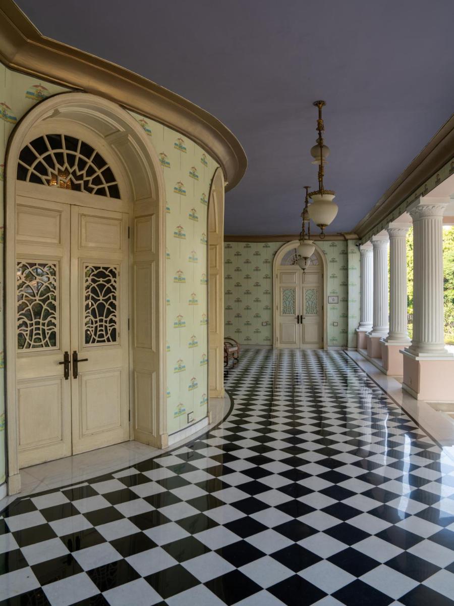 an empty hallway with a checkered floor and doors at Rajmahal Palace RAAS in Jaipur