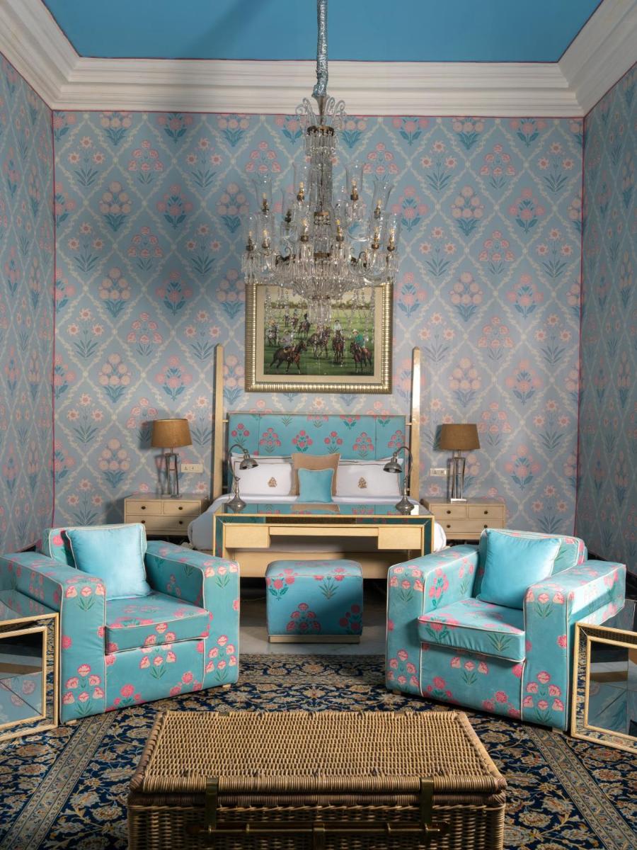 a living room with blue furniture and a chandelier at Rajmahal Palace RAAS in Jaipur