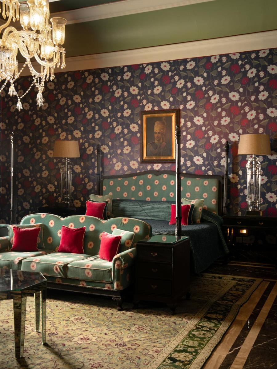 a living room with a couch and floral wallpaper at Rajmahal Palace RAAS in Jaipur